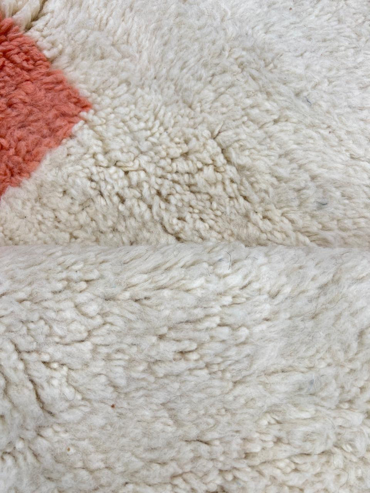 Round Moroccan wool rug with modern abstract design in brown, peach, and white.