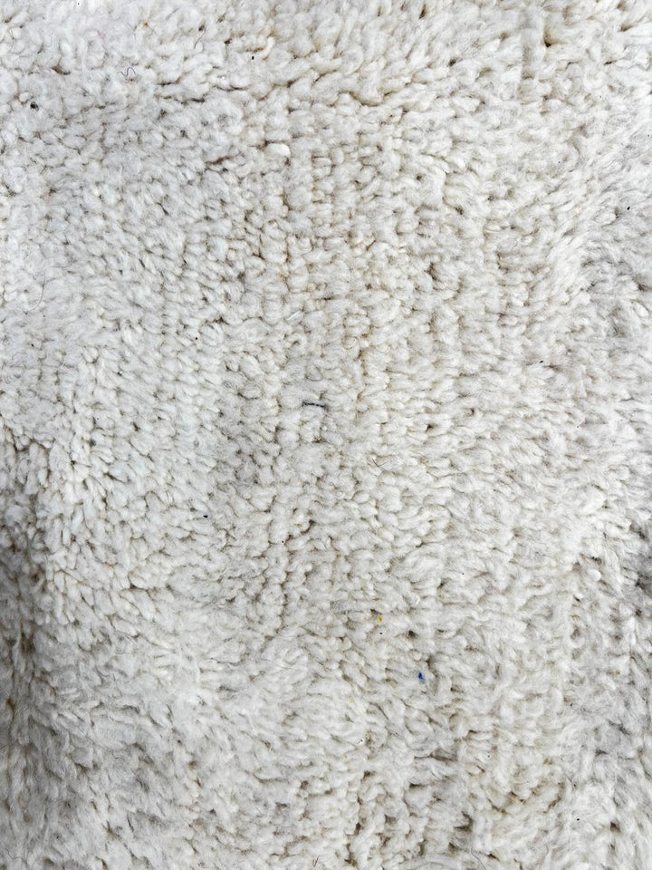 Handmade abstract Moroccan wool runner rug with cream base, pink line, blue shapes, green and mustard geometric accents.
