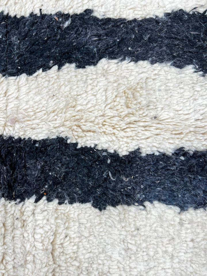 Handmade ivory Moroccan wool rug with orange, black, yellow, and gray abstract stripe patterns – modern Berber rug