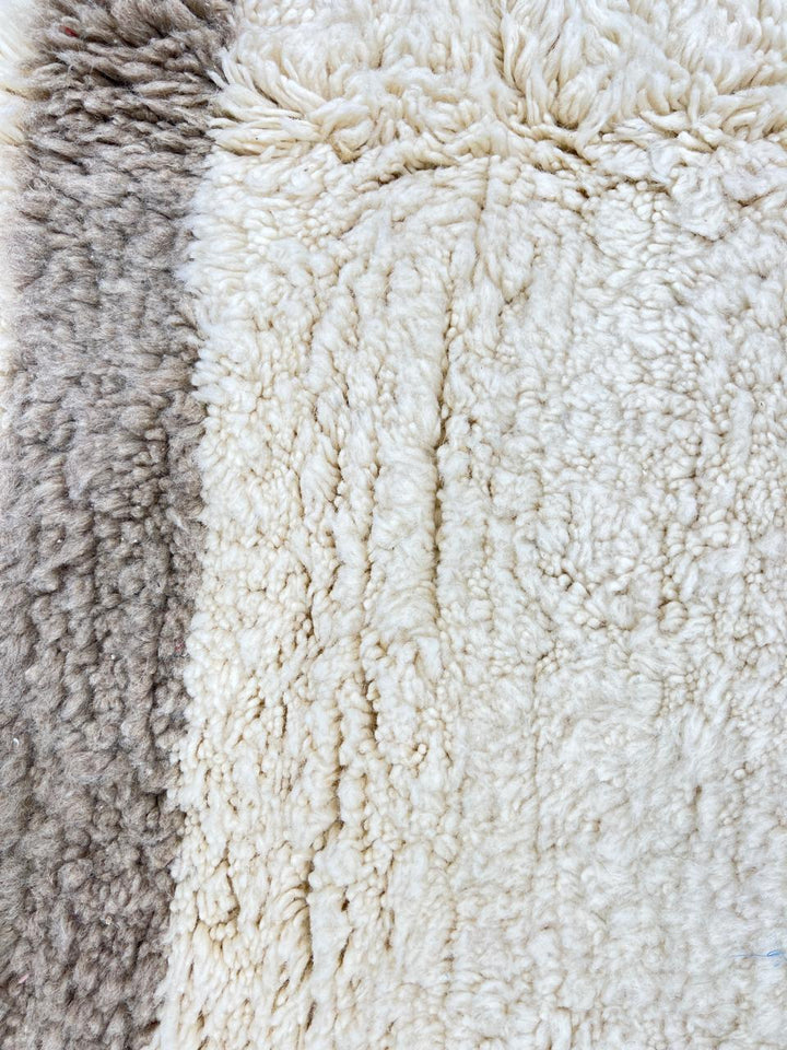 Beige minimalist Moroccan wool rug with geometric border pattern