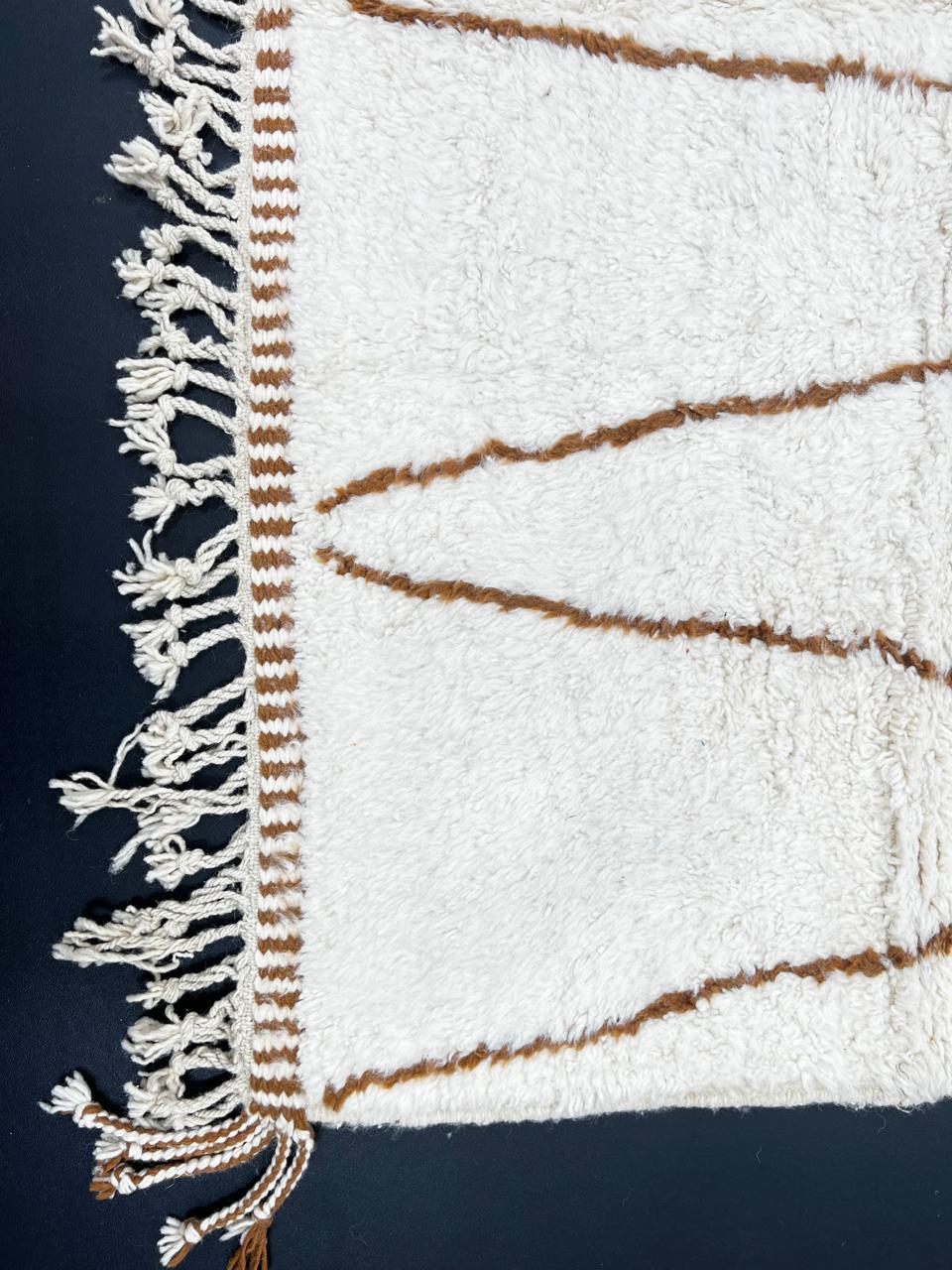 Beige and brown Moroccan wool rug with geometric design, handmade by Berber artisans using natural wool