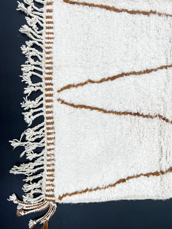 Beige and brown Moroccan wool rug with geometric design, handmade by Berber artisans using natural wool