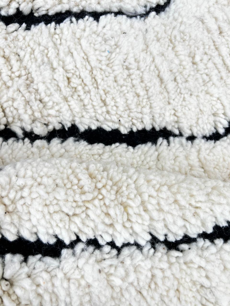 Black and white Moroccan runner rug with diamond geometric pattern made of handmade wool and black fringed ends