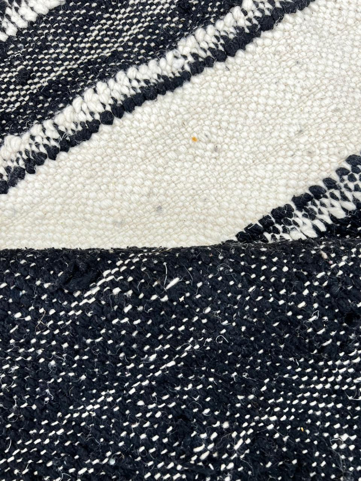 Black and white Moroccan kilim runner rug with central white stripe, handwoven flatweave wool carpet in minimalist design, perfect as hallway Moroccan runner and modern boho floor decor.