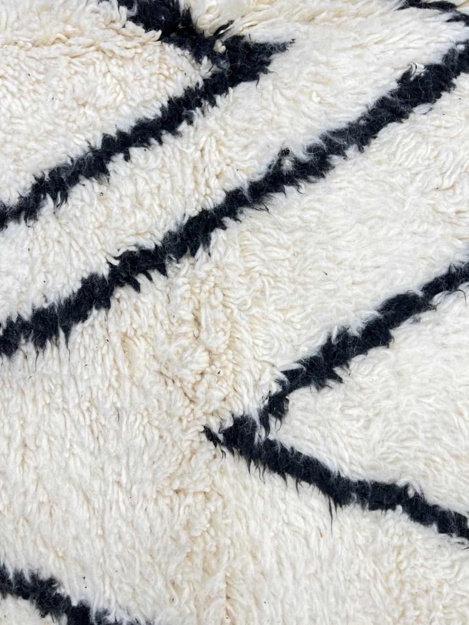 Black and white Moroccan wool runner rug with Beni Ourain diamond pattern and fringed edges