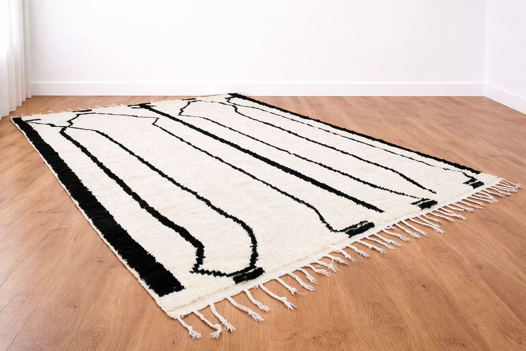 Black and white Moroccan Berber wool rug with linear geometric pattern, handmade plush shag rug with tassels