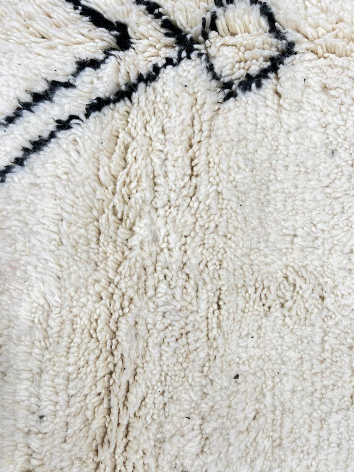 Black and white handmade Beni Ourain Moroccan wool rug with geometric diamond design and fringed edges