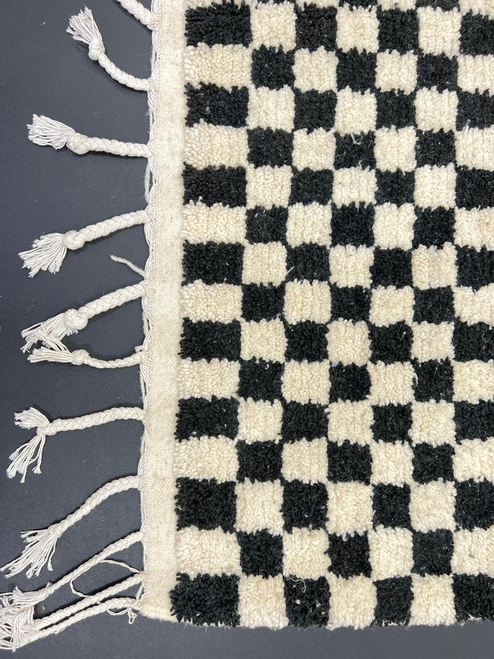 Handwoven black and white Moroccan wool rug with checkerboard pattern