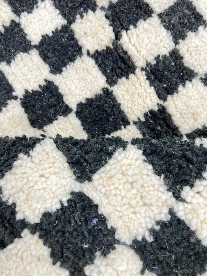 Handwoven black and white Moroccan wool rug with checkerboard pattern