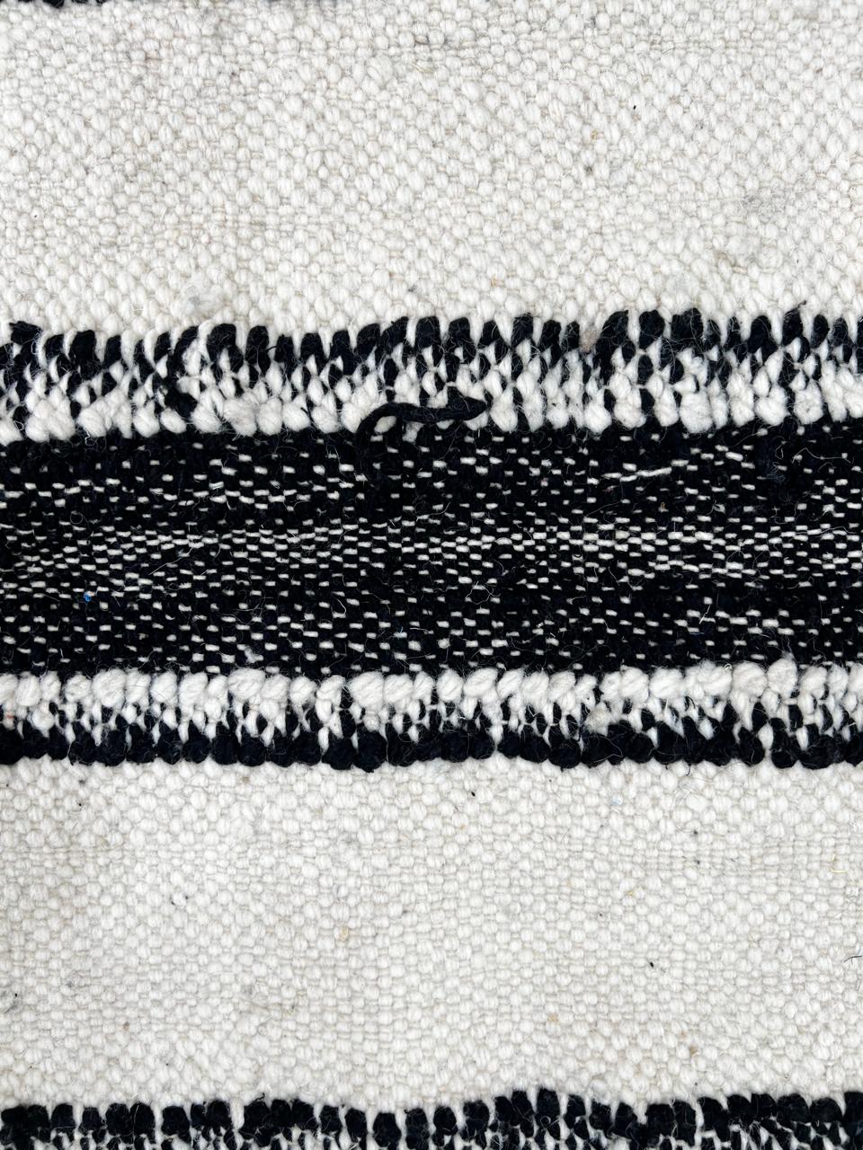 Black and white Moroccan wool rug with vertical stripe design, handmade by Berber artisans