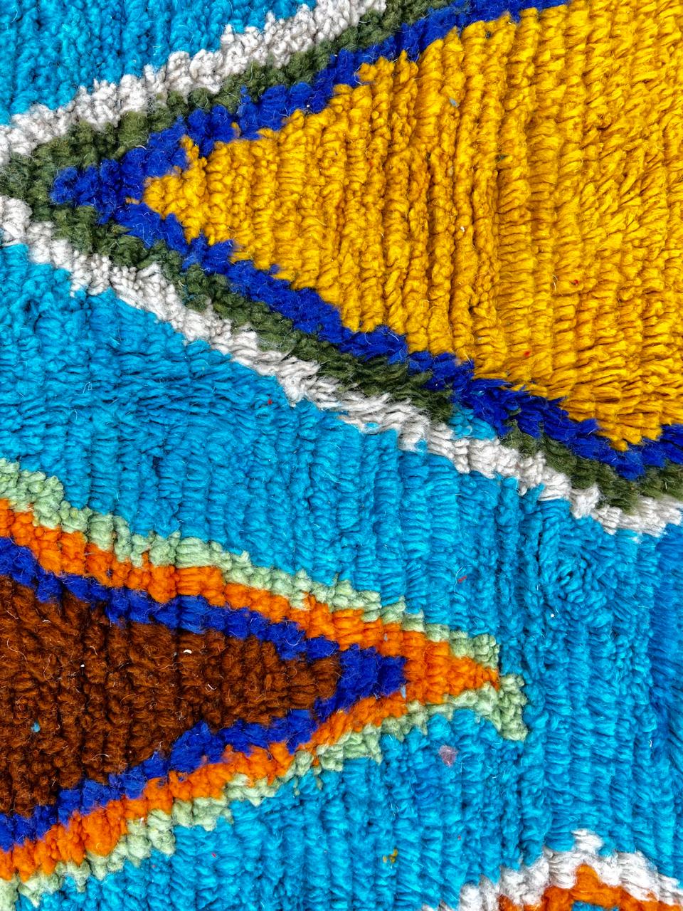 Handmade blue Moroccan wool runner rug with colorful Berber geometric motifs in orange, green, brown, navy, fuchsia, and cream
