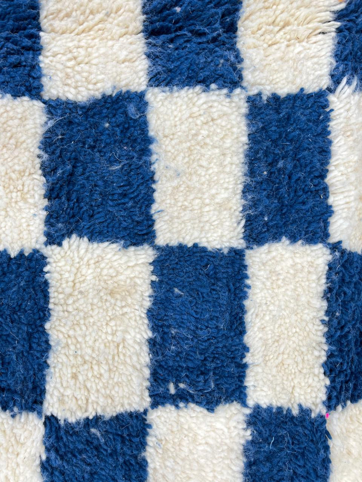 Handwoven blue and white Moroccan wool rug with checkerboard pattern