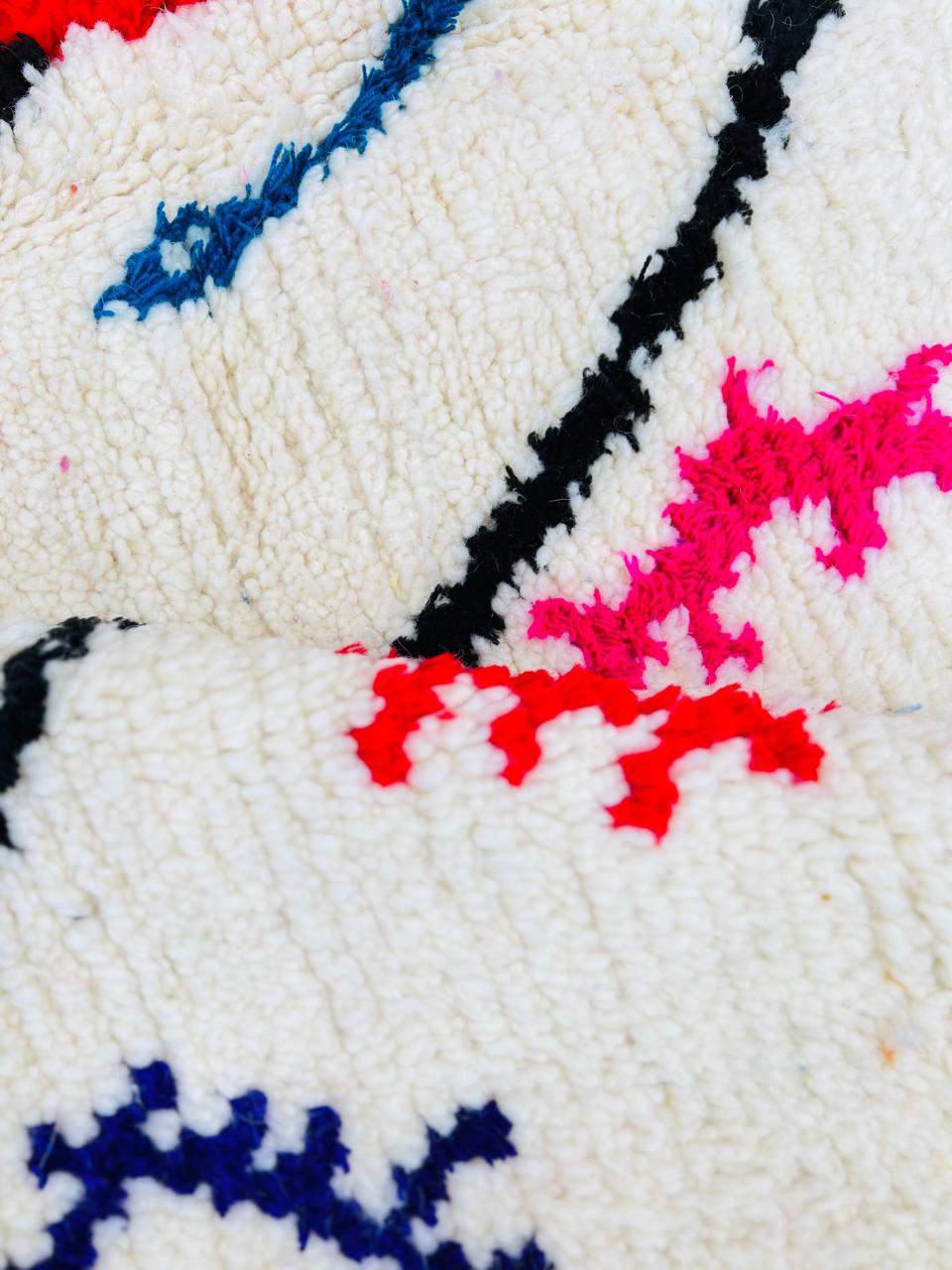 Colorful Berber Moroccan runner rug with diamond pattern and multicolor tribal symbols on cream wool background