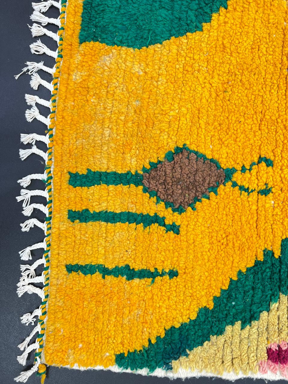 Handwoven colorful Moroccan wool rug with abstract geometric design in pink, yellow, green, and black tones