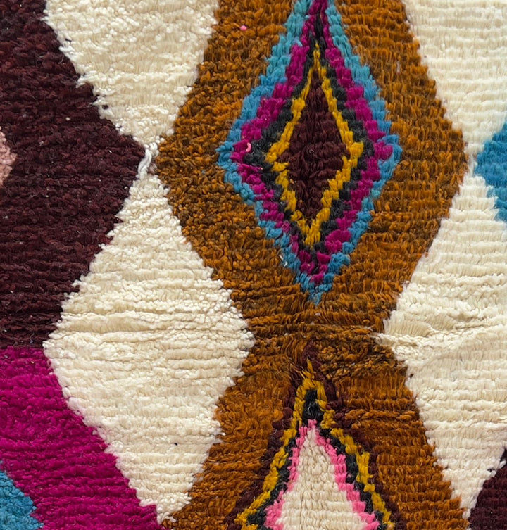 Handmade colorful Moroccan wool runner rug with zigzag geometric patterns in pink, teal, brown, mustard, and ivory tones