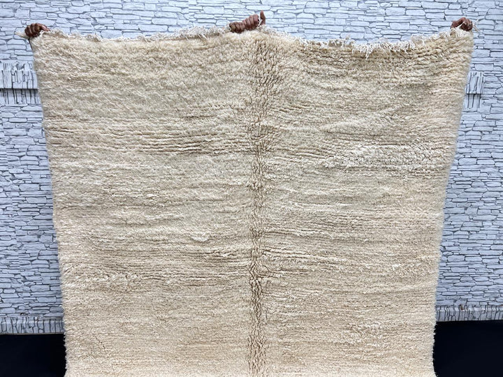 Cream handmade Moroccan wool rug with soft plush texture and fringed edges