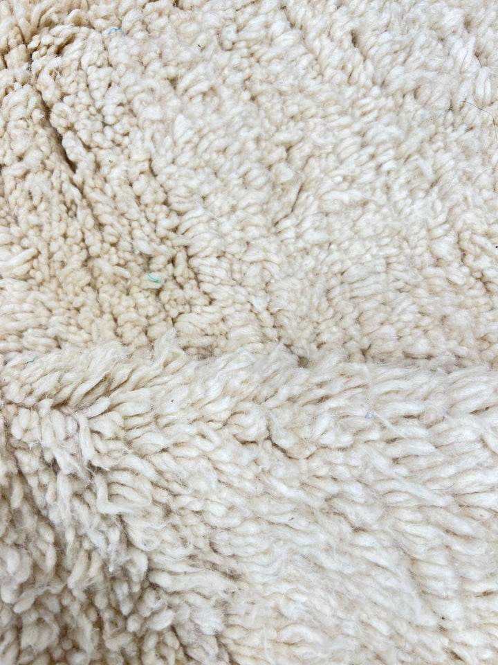 Cream handmade Moroccan wool rug with soft plush texture and fringed edges
