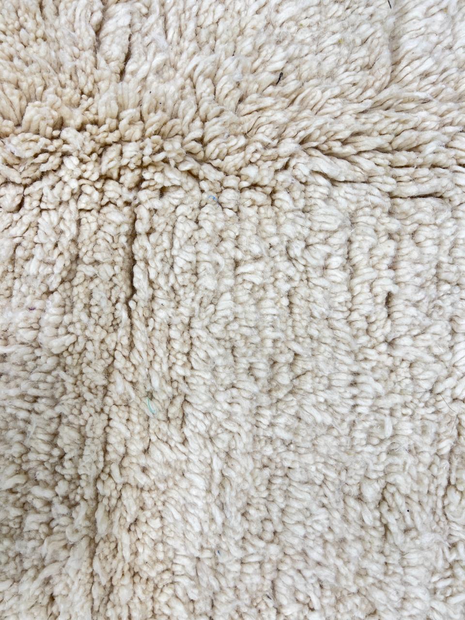 Cream handmade Moroccan wool rug with soft plush texture and fringed edges