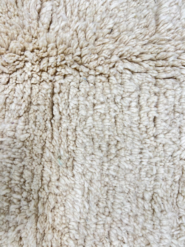 Cream handmade Moroccan wool rug with soft plush texture and fringed edges