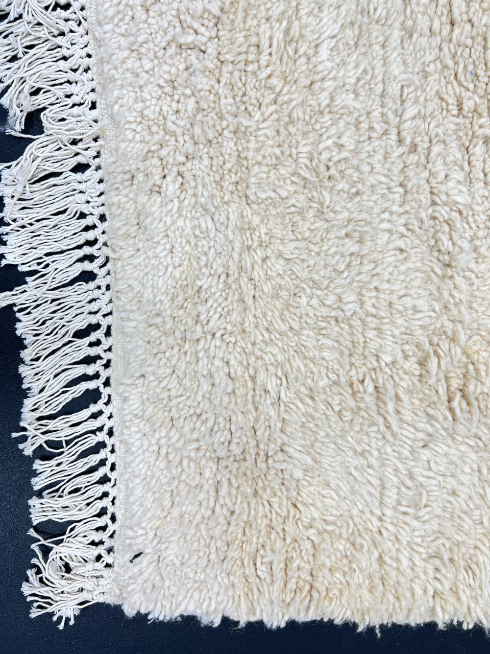 Cream handmade Moroccan wool rug with soft plush texture and fringed edges