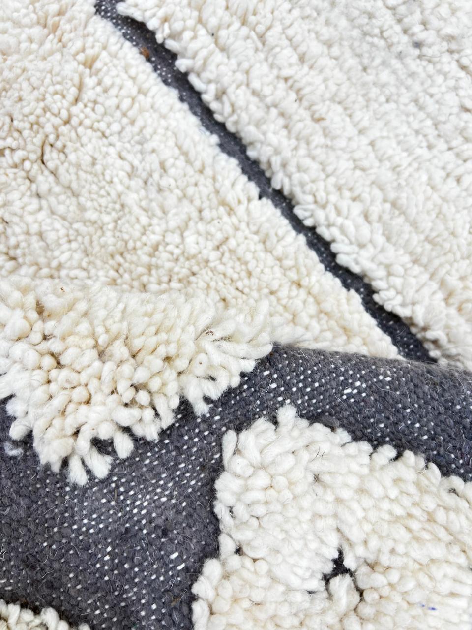 Cream Moroccan wool rug with charcoal gray geometric border and linear Berber pattern