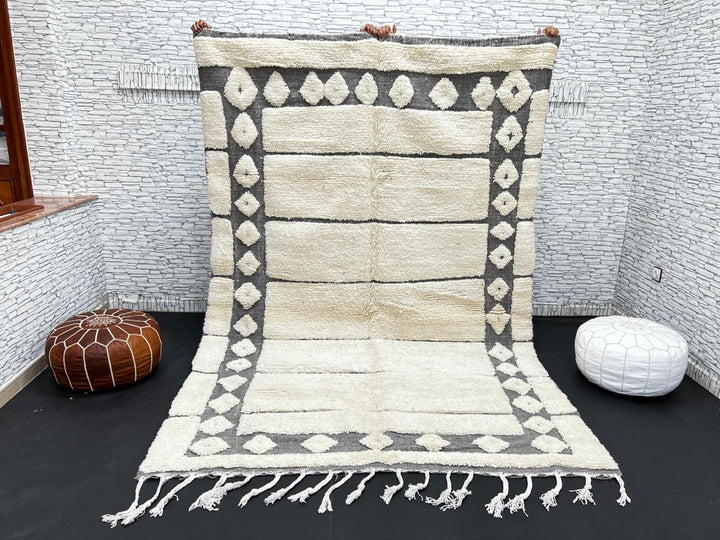 Cream Moroccan wool rug with charcoal gray geometric border and linear Berber pattern