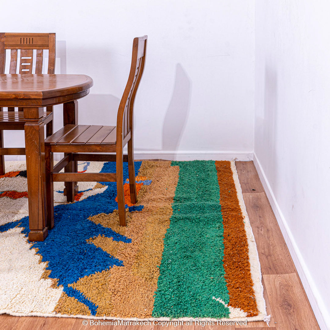 Colorful Moroccan rug with abstract camel design, handwoven from natural wool, complements dining room decor.