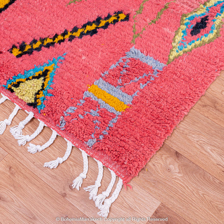 Colorful bright pink Moroccan wool rug with blue and yellow diamond patterns