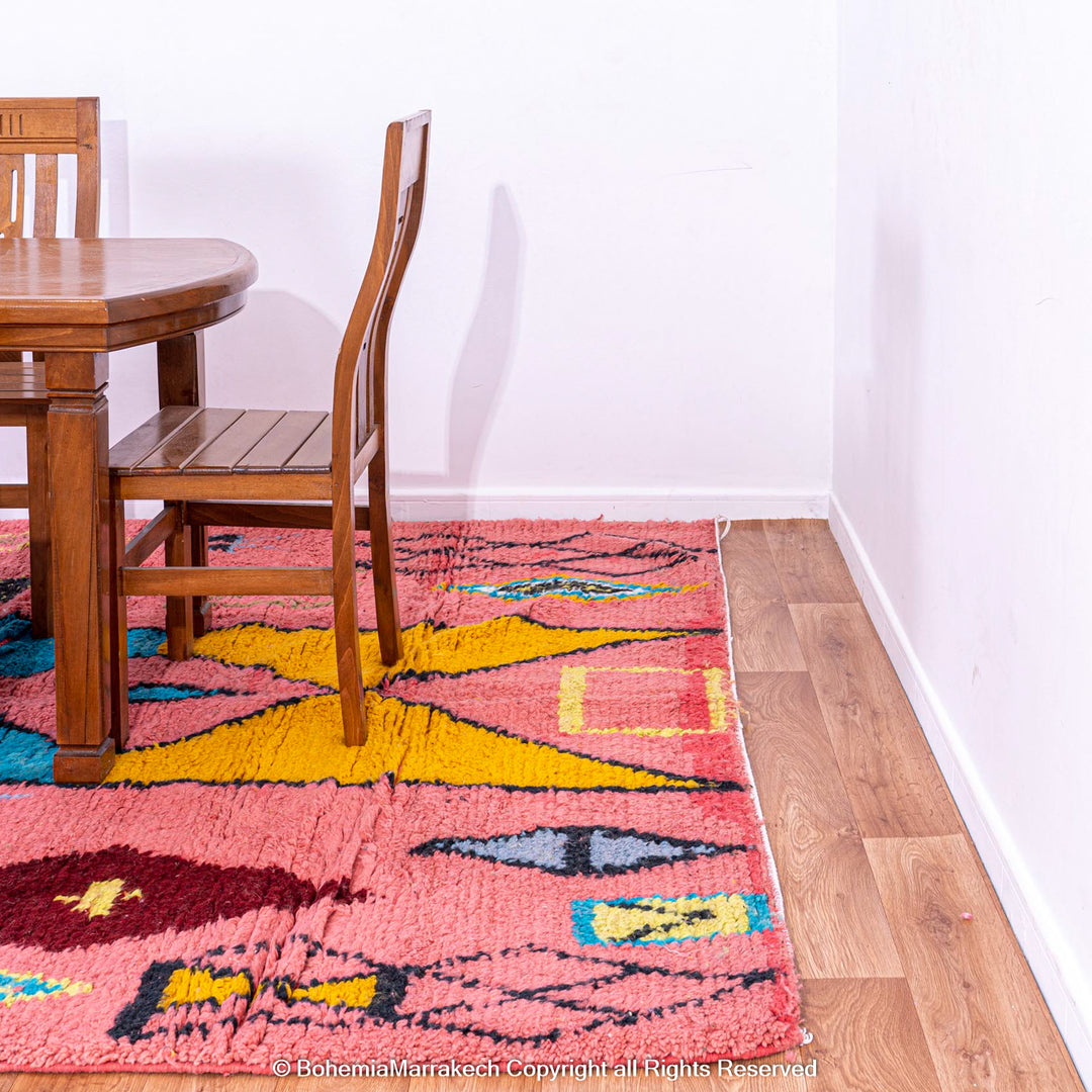 Colorful bright pink Moroccan wool rug with blue and yellow diamond patterns