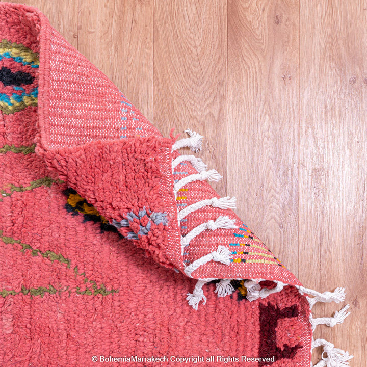 Colorful bright pink Moroccan wool rug with blue and yellow diamond patterns