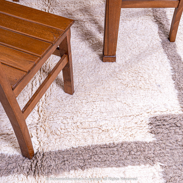 Minimalist Moroccan wool rug with beige border design on cream background