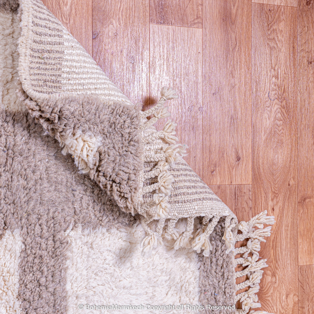 Minimalist Moroccan wool rug with beige border design on cream background