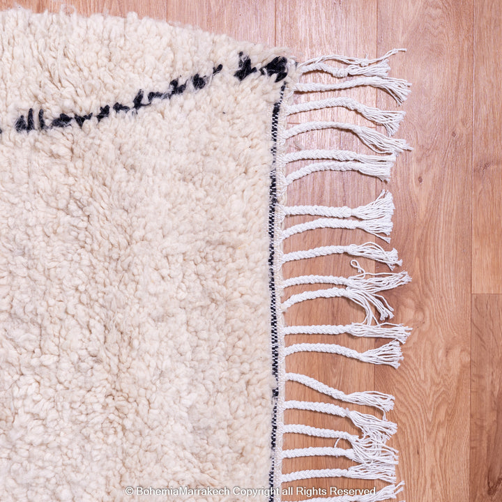 Handmade Beni Ourain Moroccan wool rug with black diamond design on cream background
