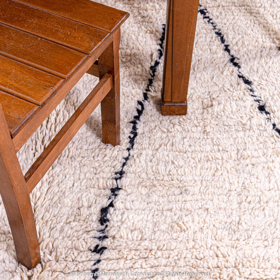 Handmade Beni Ourain Moroccan wool rug with black diamond design on cream background