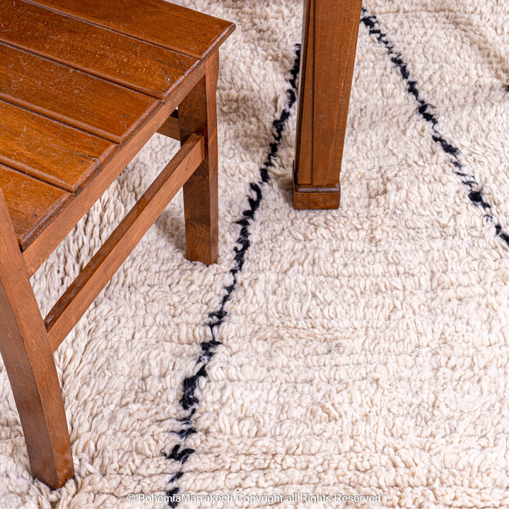 Handmade Beni Ourain Moroccan wool rug with black diamond design on cream background