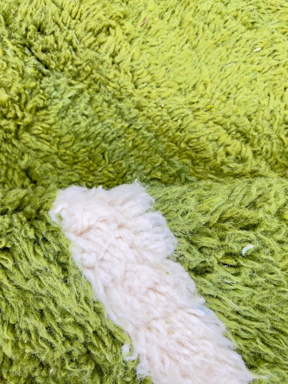 Handmade Moroccan runner rug with vibrant green and white abstract design, crafted from natural wool by Berber artisans.