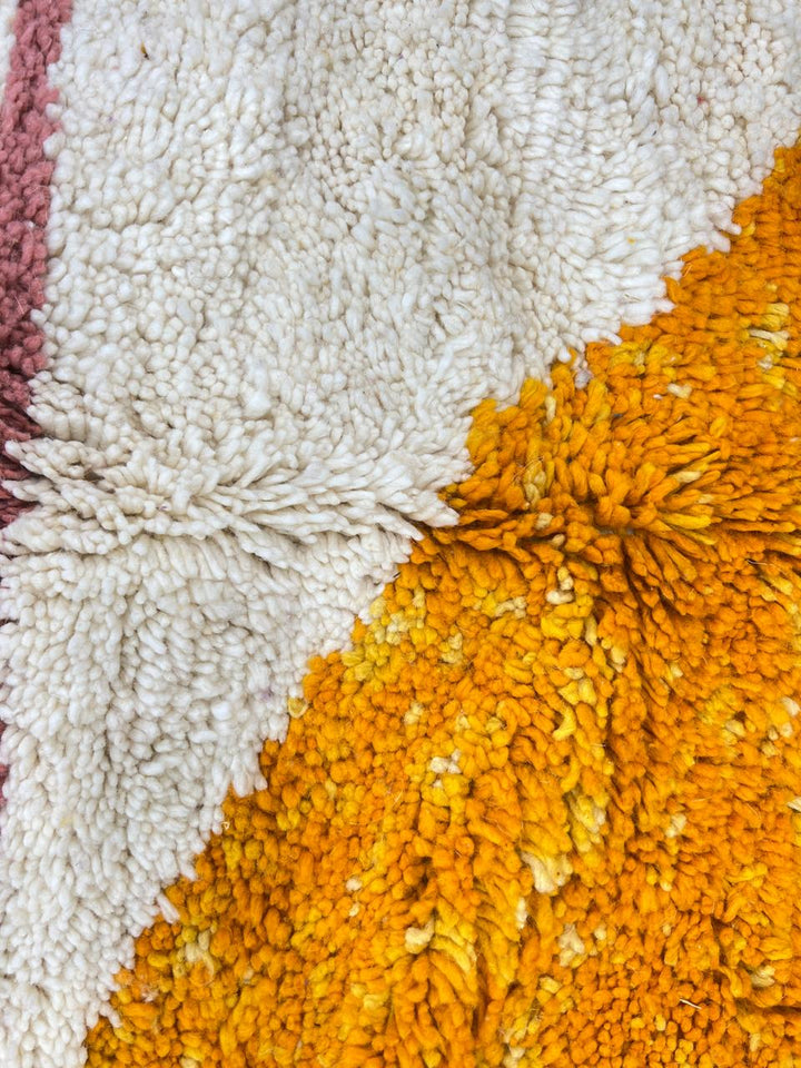 Handmade Moroccan wool rug with abstract Berber design in purple and yellow, round shape.
