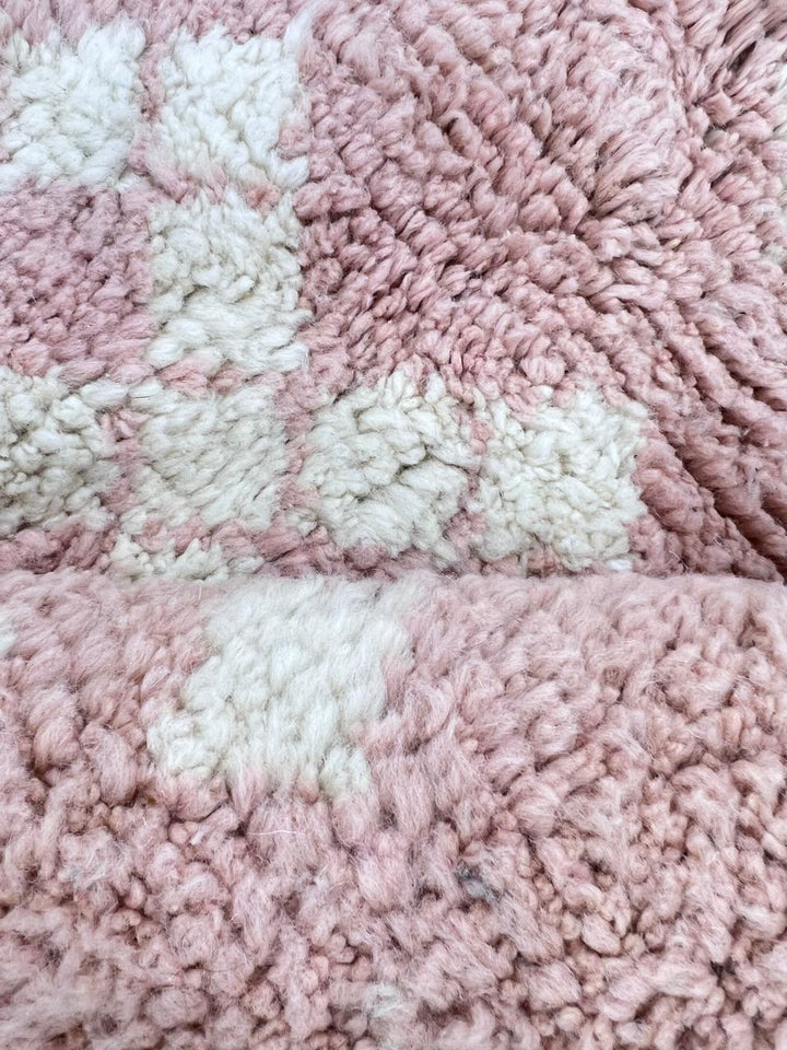 Round pink Moroccan wool rug with ivory diamond Berber motifs and fine black geometric lines, handmade Amazigh wool area rug.