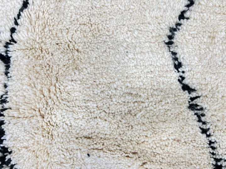 Handwoven white and black Moroccan wool runner rug with minimalist geometric lines, inspired by Beni Ourain design