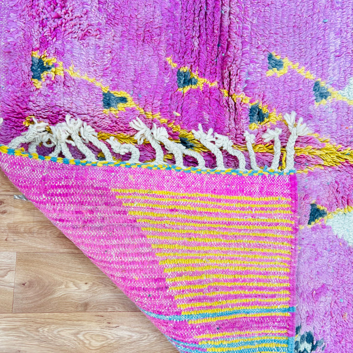 Handwoven vintage Moroccan rug in pink, yellow, and blue with triangular patterns, showcasing traditional Berber artistry, wool material.
