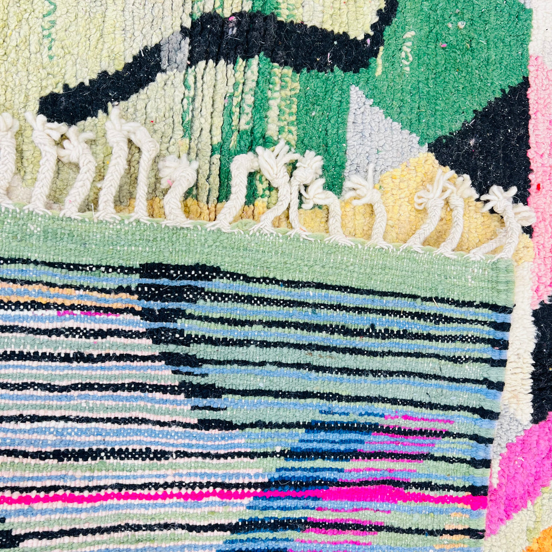 Vintage Moroccan Berber rug with vibrant geometric patterns in green, pink, orange, cream, and black, handwoven in 100% wool.
