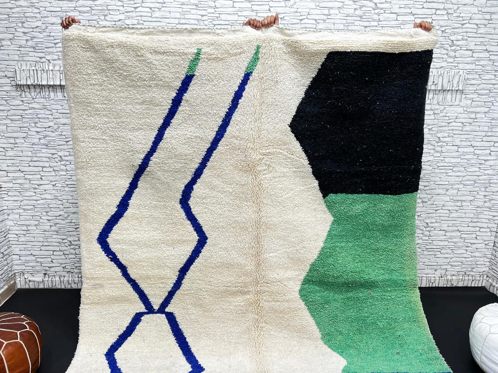Handmade ivory Moroccan wool rug with green, blue, and black geometric abstract patterns