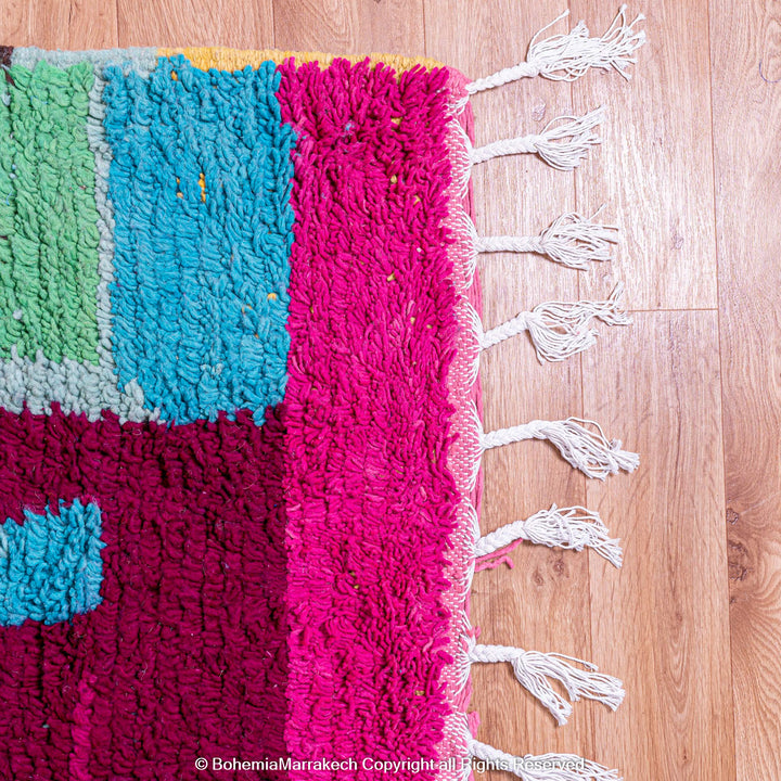 Handmade Moroccan rug with colorful striped and tribal motifs in vibrant wool