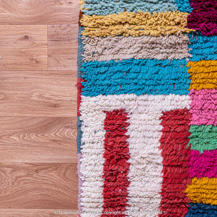 Handmade Moroccan rug with colorful striped and tribal motifs in vibrant wool