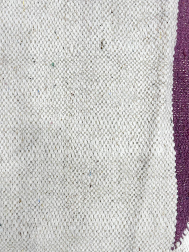 Flat weave round Moroccan wool rug with minimalist abstract pink and purple design on white background