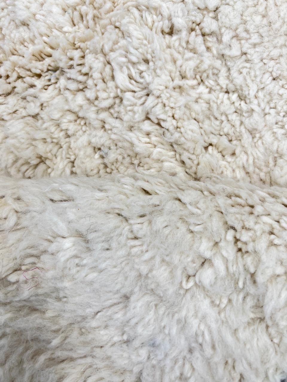 Handmade Moroccan runner rug with white wool center, blue borders, and beige accents, crafted by Berber artisans.
