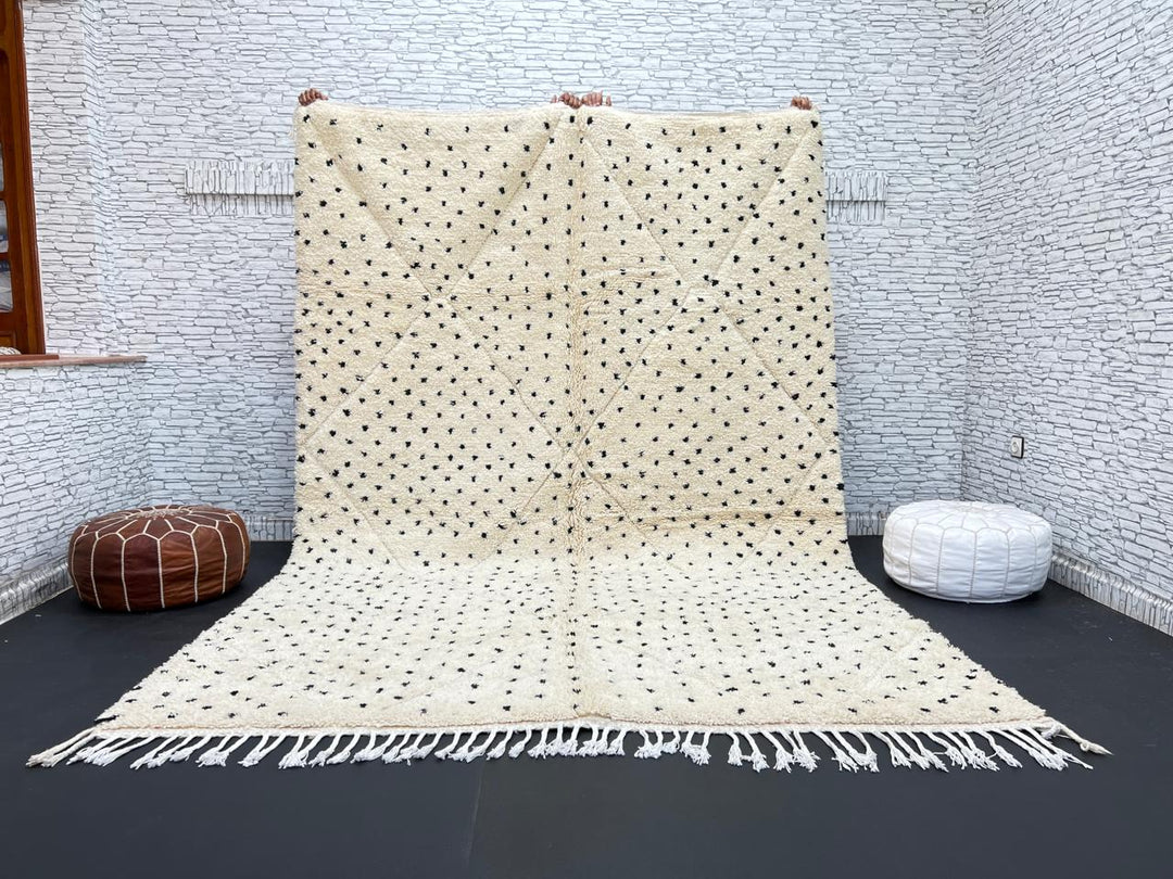 Handwoven Moroccan wool rug with small black dotted patterns on an ivory background, minimalist Beni Ourain design