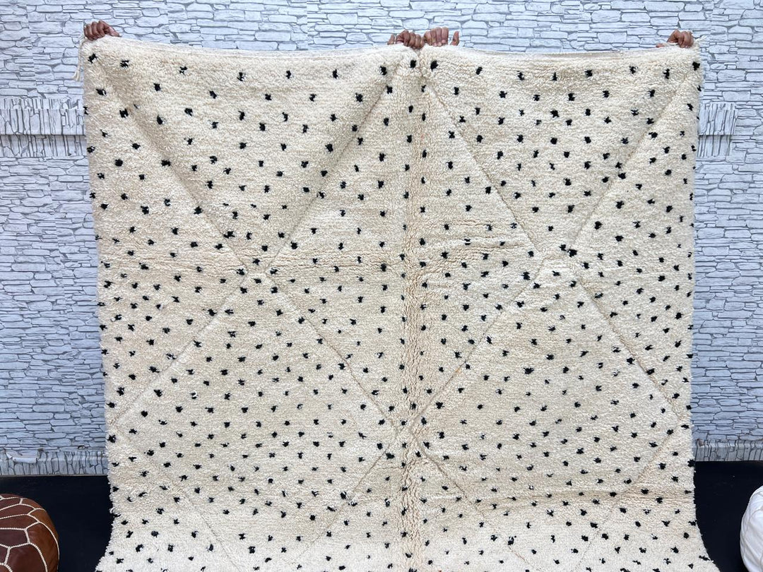 Handwoven Moroccan wool rug with small black dotted patterns on an ivory background, minimalist Beni Ourain design