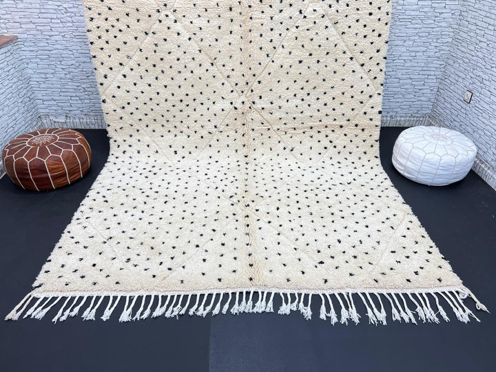 Handwoven Moroccan wool rug with small black dotted patterns on an ivory background, minimalist Beni Ourain design