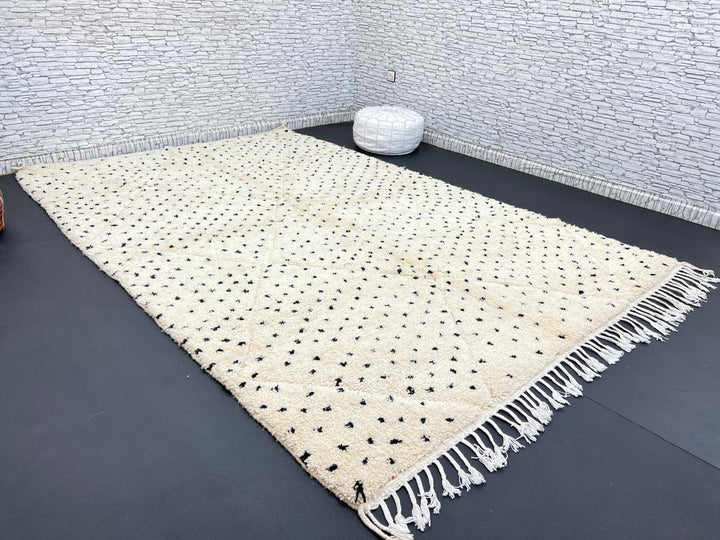 Handwoven Moroccan wool rug with small black dotted patterns on an ivory background, minimalist Beni Ourain design